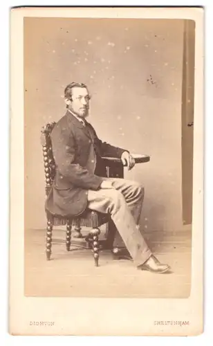 Fotografie R. Dighton, Cheltenham, englischer Herr im Anzug mit Vollbart sitzend im Atelier