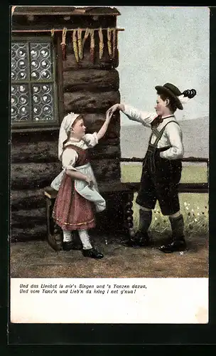 AK Kinderpaar in Tracht beim Tanz vor einem Holzhaus