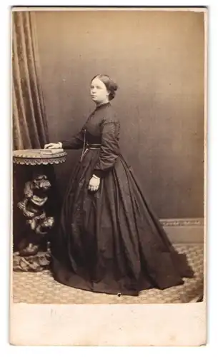 Fotografie Stuart Brothers, Knightsbridge, junge englische Frau im schwarzen Kleid posiert stehend im Atelier