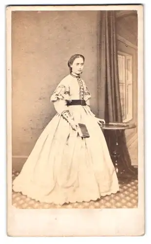 Fotografie Monkhouse & Co., York, junges englisches Mädchen im weissen Kleid mit traurigem Blick