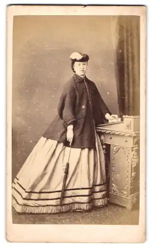 Fotografie Symonds, Portsmouth, Engländerin im hellen Kleid mit Jacke und Schirm trägt Hut im Atelier