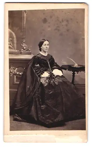 Fotografie F. Spalding, Chelmsford, englsiche Dame im schwarzen seidenen Kleid posiert sitzend im Atelier