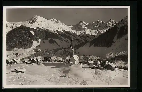 AK Mittelberg, Ortspartie mit Kirche, Hammersppitze und Schafalpköpf im Schnee