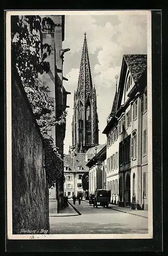 AK Freiburg i. Br., Strassenpartie mit Blick zur Kirche