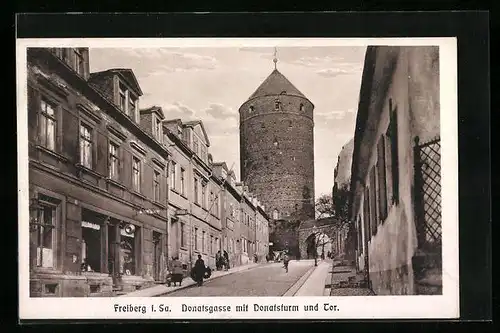AK Freiberg i. Sa., Strasse Donatsgasse mit Geschäft, Donatsturm und Tor