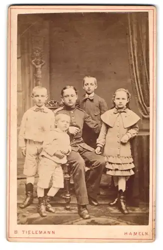 Fotografie B. Tielemann, Hameln, Portrait junger Knabe als Soldat in Uniform, Kindersoldat mit seinen Geschwistern