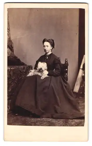 Fotografie C. A. Duval & Co., Manchester, Exeter St. 14, junge Engländerin im Kleid mit ihrem Hund auf dem Schoss, 1869