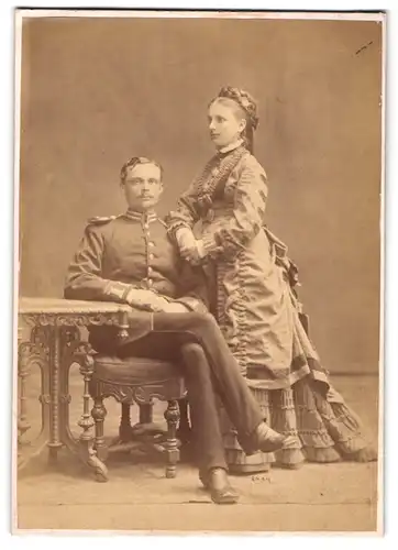 Fotografie unbekannter Fotograf und Ort, Soldat in Garde Uniform mit Epauletten nebst seiner Frau im Atelier