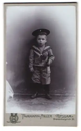 Fotografie Photograph Atelier, Potsdam, junger Knabe als Matrose in mit Mützenband Kaiserliche Marine mit Horn