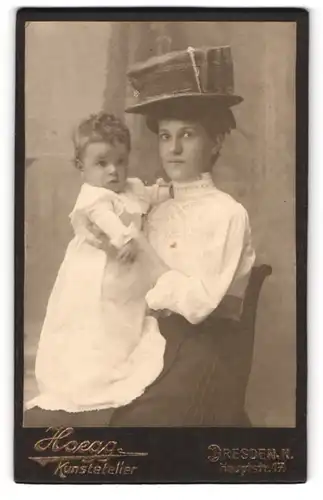 Fotografie Hoegg, Dresden, junge Mutter mit hohem Hut hällt Kind im Arm