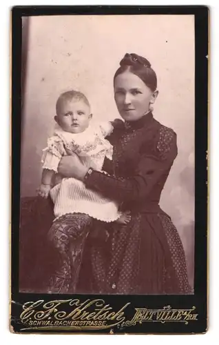 Fotografie C. F. Kretsch, Eltville a. Rh., junge Mutter im dunklen Püktchenkleid mit süssem Kleinkind im Arm, Mutterglück