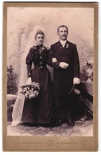 Fotografie Mürnseer, Karlsruhe, junges Brautpaar im schwarzen Hochzeitskleid und im Anzug mit Zylinder