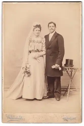 Fotografie Schmidt, Graslitz, junges tschechisches Brautpaar im weissen Hochzeitskleid und Mann im Anzug nebst Zylinder