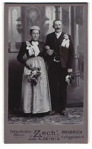 Fotografie Atelier Zech, Innsbruck, österreichisches Brautpaar im schwarzen Kleid mit Schürze und im Anzug
