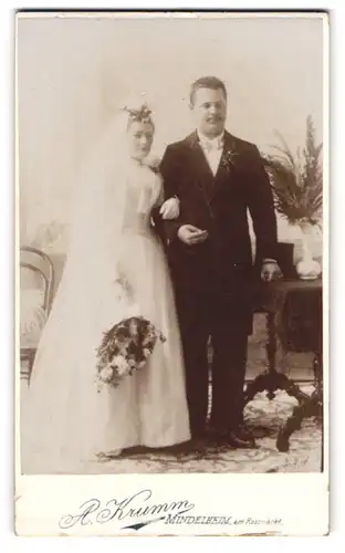 Fotografie A. Krumm, Mindelheim, junges Ehepaar im Hochzeitskleid und Anzug posieren im Atelier