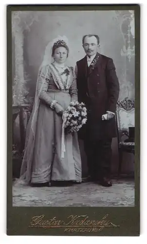 Fotografie Gustav Kadansky, Kratzau, älteres Brautpaar im schlichten Hochzeitskleid mit Schleier und im Anzug