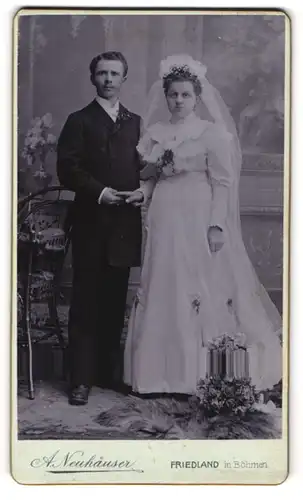 Fotografie A. Neuhäuser, Friedland i. Böhen, junges Brautpaar im weissen Hochzeitskleid und im Anzug mit Brautstrauss