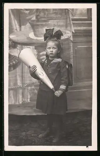 Foto-AK Mädchen mit Zuckertüte, Schleife im Haar, Schulanfang