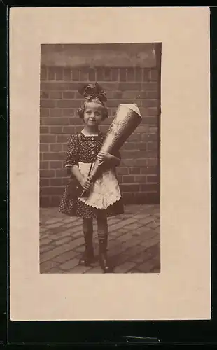Foto-AK Mädchen mit Zuckertüte und Schleife im Haar, Schulanfang