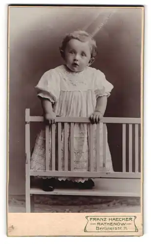 Fotografie Franz Haecker, Rathenow, Berlinerstrasse 11, kleines niedliches Mädchen posiert neugierig in einem Kleidchen