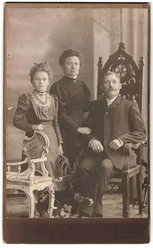 Fotografie M. Appel, Berlin, Mutter und Vater im Anzug und im dunklen Kleid mit ihrer Tochter im Atelier