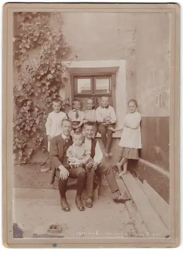 Fotografie unbekannter Fotograf und Ort, 8 Kinder in zeitgenössischer Kleidung posieren im Hinterhof, Knaben und Mädchen