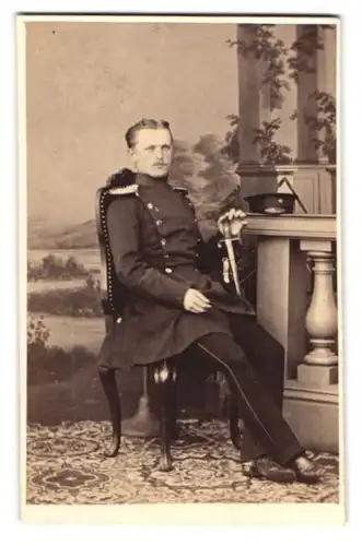 Fotografie unbekannter Fotograf und Ort, junger Soldat in Uniform mit Epauletten udn Säbel sitzend im Atelier