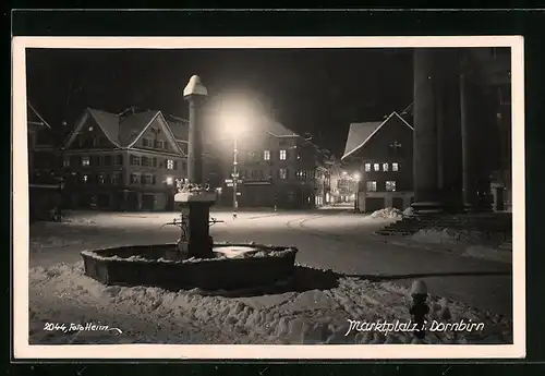 AK Dornbirn, Marktplatz mit Brunnen im Schnee bei Nacht