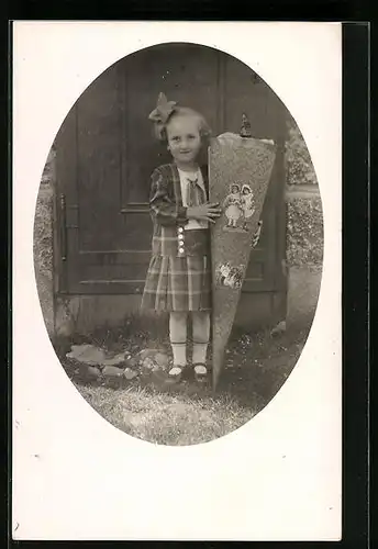 Foto-AK Mädchen mit Zuckertüte und Schleife im Haar zum Schulanfang