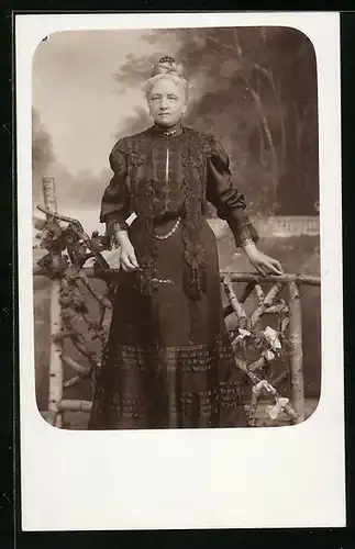 Foto-AK Ältere Dame in schwarzem Kleid vor Studiokulisse