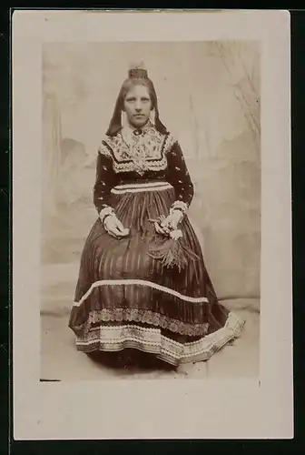 Foto-AK Junge Frau in Volkstracht vor Studiokulisse