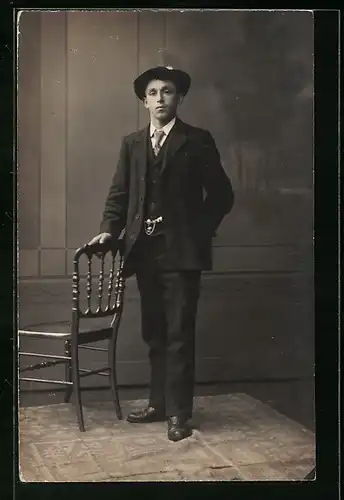 Foto-AK Junger Mann mit Hut im Dreiteiler vor Studiokulisse