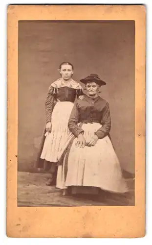 Fotografie unbekannter Fotograf und Ort, Grossmutter und Enkelin in österreichischen Trachtenkleidern posieren im Atelier