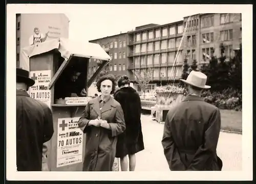 Fotografie Losbude der Rot Kreuz-Lotterie, Losverkäuferin bei der Arbeit