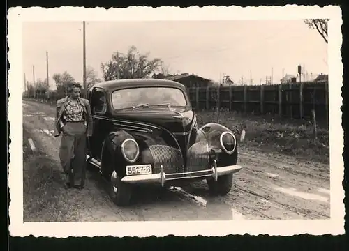 Fotografie Auto Ford, Dame neben schwarzer Limousine