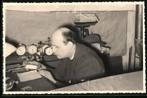Fotografie Uhrmacher repariert einen Wecker in seiner Werkstatt
