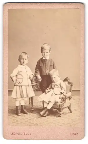 Fotografie Leopold Bude, Graz, drei Knaben Theodor, Richard und Guido Hafmann in Kleidern und im Anzug auf Kindermöbeln