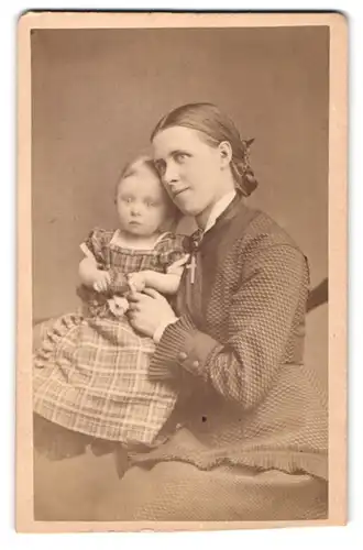 Fotografie F. Bröcking, Apenrade, junge dänische Mutter mit ihrer Tochter im karierten Kleid auf dem Schoss, Mutterglück