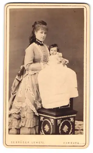 Fotografie Gebrüder Lewetz, Hamburg, Mutter im schicken Kleid mit ihrem Neugeborenen im Arm, Mutterglück