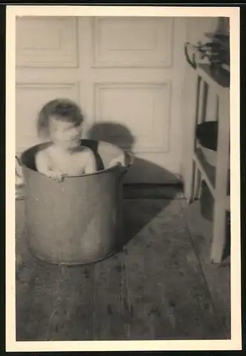 Fotografie Kleinkind beim Baden in einem grossen Topf