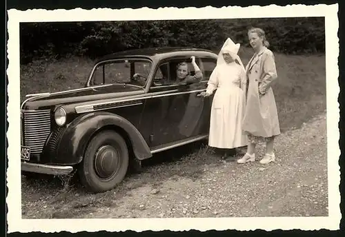 Fotografie Auto Opel Olympia, Ordensschwester neben dem PKW
