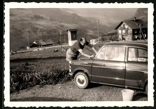 Fotografie Auto NSU Prinz, Fahrer putzt sein PKW