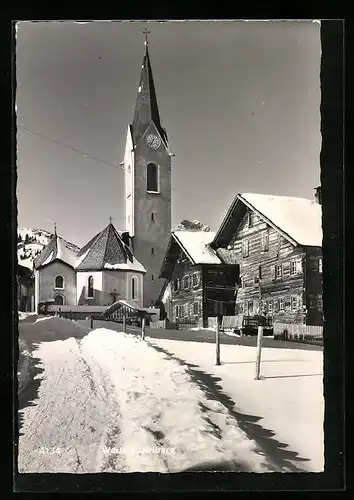 AK Warth a. Arlberg, Strassenpartie mit Kirche im Schnee