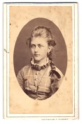 Fotografie Jungmann & Albert, Bodenbach i. Böhmen, junges Mädchen im karierten Kleid mit langem Zopf und Haarschleife
