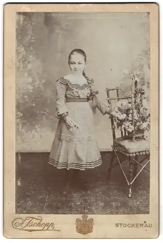 Fotografie Oskar Hopp, Stockerau, kleines Mädchen im karierten Kleid mit langem Zopf posiert im Atelier