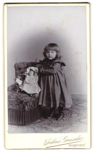 Fotografie Julius Grusche, Neugersdorf, kleines sächsisches Mädchen im Kleid mit Puppe auf dem Sessel