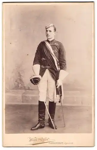 Fotografie Wilh. Pöllot, Darmstadt, junger Student im vollen Wichs mit Schläger und Biertönnchen, 1900