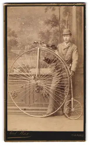 Fotografie Ferd. Max, Hanau, junger Mann im Anzug mit seinem Hochrad und Schutzhelm