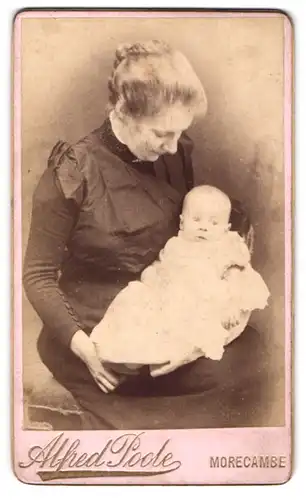 Fotografie Alfred Pode, Morecambe, Mutter im schwarzen Kleid mit ihrem Neugeborenen im Arm, Mutterglück
