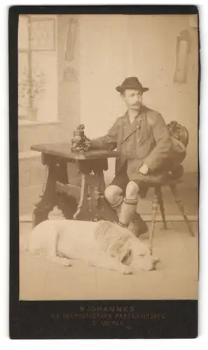 Fotografie B. Johannes, Meran, junger Mann mit seinem Hund im heimischen Wohnzimmer, Studiokulisse